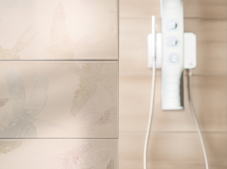 RAKO | Koupelna v šedých a béžových odstínech s dekorací ve stylu akvarelové malby. Lesklé obkládačky ve formátu 30 x 60 cm.