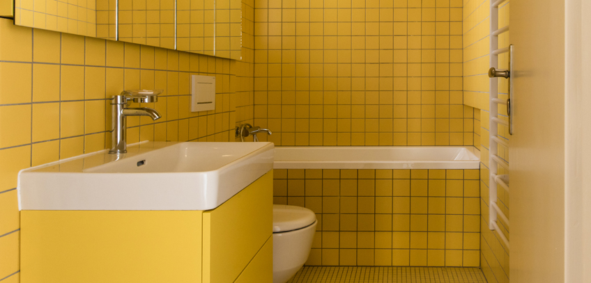 Byt s mentolovou kuchyní a žlutou koupelnou