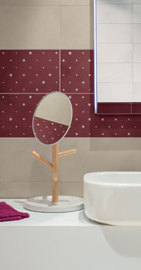 RAKO | Detailní záběr na část koupelny. Obklady v béžové barvě a s dekorem v bordó odstínu s puntíky.