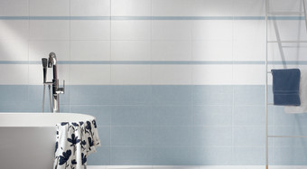 RAKO | Koupelna nakombinovaná z obkladů v modré barvě s bílým dekorem s pruhy a modrou listelou.