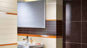 RAKO | Koupelna v kombinaci světle béžové a hnědé barvy. Jako doplněk oranžová listela.