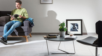 RAKO | Velkoformátová dlažba v šedé barvě s imitací kamene, využitá v obývacím pokoji.