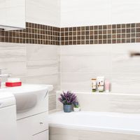 RAKO | Koupelna s imitací mramoru ve světle šedé barvě. Mozaika ze série Board s imitací dřeva v tmavě hnědé barvě.