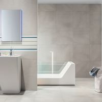 RAKO | Koupelna z obkladů v béžové a modré barvě. Dekor v bílé barvě s pruhy. Na zemi dlažba v béžové barvě.