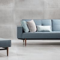 RAKO | Obývací pokoj v industriálním stylu. Na zdi i na zemi dlažba ve velkém formátu 60 x 120 cm v šedé barvě s imitací betonu.