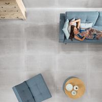 RAKO | Obývací pokoj v industriálním stylu v imitaci betonu s dlažbou na zdi i na zemi ve velkém formátu 60 x 120 cm v šedé barvě.