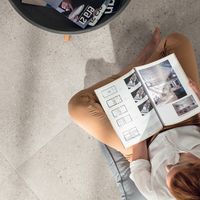 RAKO | Pohled shora na dlažbu s imitací teraco v šedé barvě. Detailem je záběr na rejstřík formátů, které společnost vyrábí a je umístěn na začátku katalogu.