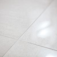 RAKO | Detail dlažby s imitací mramoru v béžové barvě.