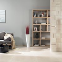 RAKO | Obývací pokoj s dlažbou ze série Rebel s imitací betonu v béžové barvě ve velkém formátu 80 x 80 cm a zeď z dekoru s pruhy.