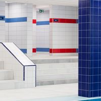 RAKO | Sociální zázemí pro muže a ženy v bazénu v Bratislavě. Prostor pro muže tvořen do modré barvy, zatímco prostor pro ženy v červeném odstínu.