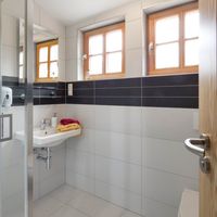 RAKO | Koupelny penzionu vytvořené ze série Fashion. Na stěny i podlahu použitá dlažba v bílé a hnědé barvě v rozměru 30 x 60 cm.