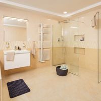 RAKO | Koupelna s elegantní imitací kamene v béžové a světle béžové barvě. Součástí dekorovaný obklad.