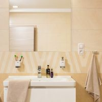 RAKO | Koupelna s elegantní imitací kamene v béžové a světle béžové barvě. Součástí dekorovaný obklad.