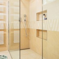 RAKO | Koupelna s elegantní imitací kamene v béžové a světle béžové barvě. Součástí dekorovaný obklad.