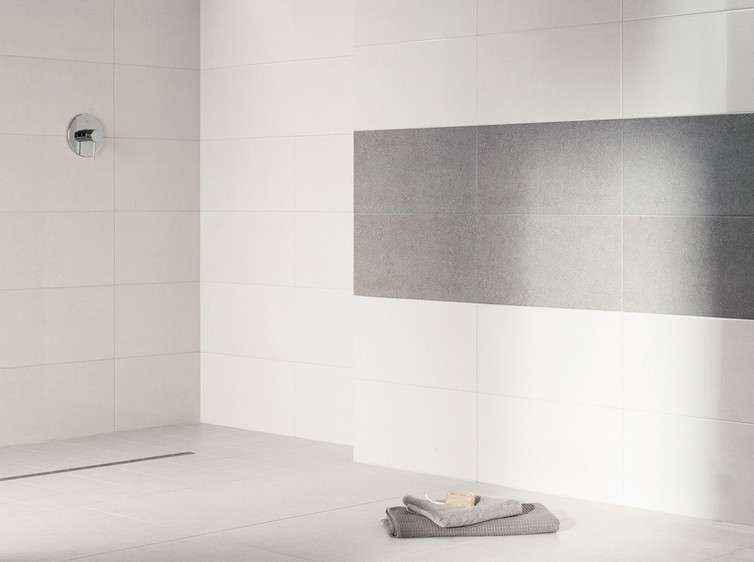 RAKO | Sociální zázemí a sprchy s imitací granitu. Nakombinované obklady ve světle šedé a tmavě šedé barvě.