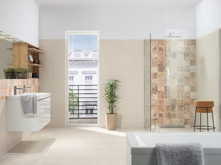 RAKO | Koupelna ve světle béžové barvě s imitací betonu. Doplněná o obklady v hnědé barvě s patchworkovým motivem.