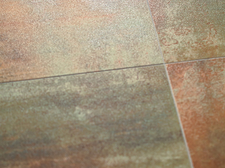 RAKO | Detail obkladů a mozaiky v měděné barvě s imitací kovu.