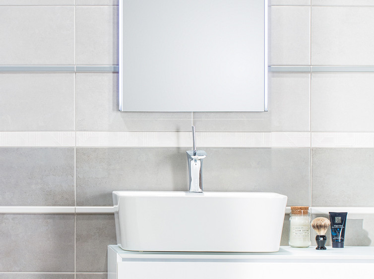 RAKO | Koupelna s kombinací formátů v bílé a šedé barvě s imitací betonové stěrky. Doplněno o dekor listely.