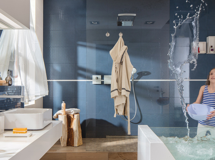 RAKO | Koupelna v jednoduchém modrém lesklém provedení se zajímavě dekorovanými obklady a mozaikou.