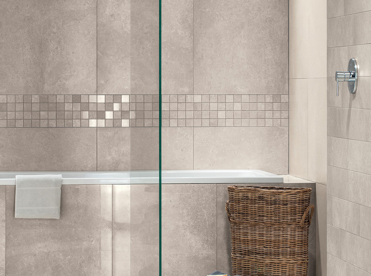 RAKO | Koupelna vytvořená z dlaždic s imitací kamene béžovošedém odstínu (na zdi) a béžovém (na zemi). Doplněno o béžovošedou mozaiku.