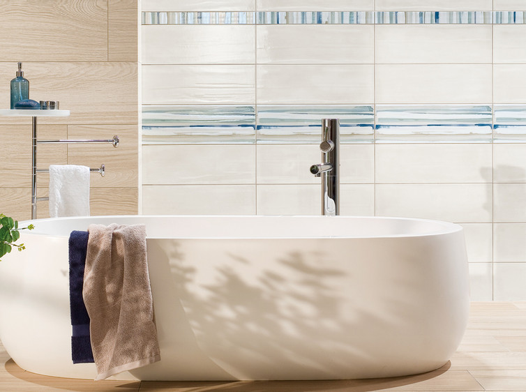 RAKO | Koupelna s lehce taženým stěrkovaným reliéfem v bílé barvě. Pruhové dekorace ve vícebarevném odstínu.